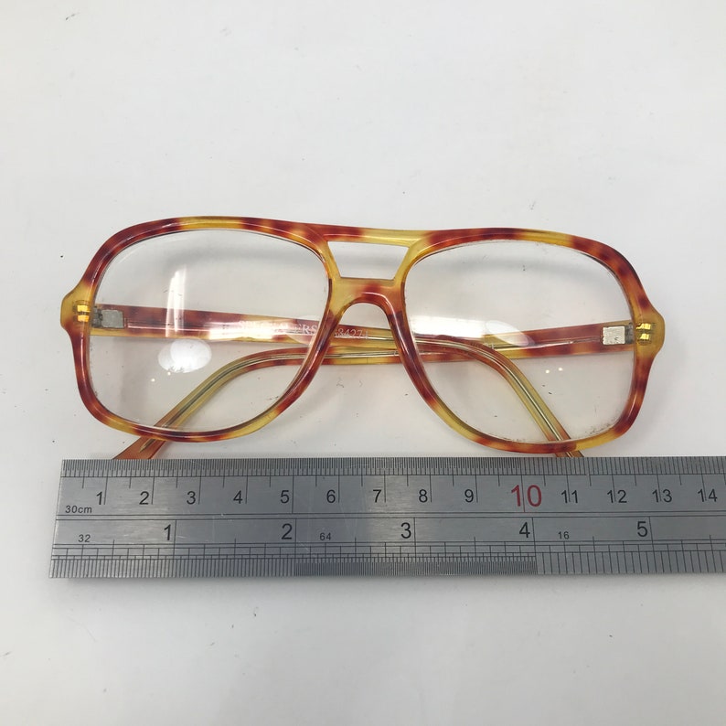 May include: Vintage aviator-style eyeglasses with a tortoiseshell pattern frame. The glasses have clear lenses and a double bridge design. The frame measures approximately 5 inches across. The glasses are set against a white background.