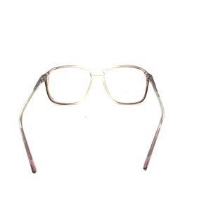 May include: Clear-framed eyeglasses with a rectangular shape. The frames transition from a light color to a darker shade of brown near the lenses. The temples are a light color that fades to a darker shade of brown.