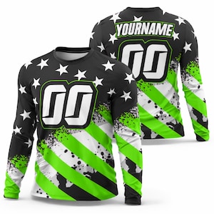 K&ouml;nnte beinhalten: Lang&auml;rmliges Trikot mit schwarzem Hintergrund, wei&szlig;en Sternen und gr&uuml;n-wei&szlig;en Streifen. Das Trikot hat gro&szlig;e wei&szlig;e Zahlen und den Text "YOURNAME" auf dem R&uuml;cken. Das Design hat einen Used-Look mit Spritzern.