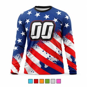 K&ouml;nnte beinhalten: Lang&auml;rmliges Trikot mit patriotischem Design. Das Oberteil hat einen blauen Hintergrund mit wei&szlig;en Sternen auf den &Auml;rmeln und der oberen Brust. Die Vorderseite hat rot-wei&szlig;e Streifen mit einem Used-Effekt und gro&szlig;e wei&szlig;e Zahlen.