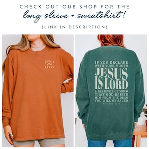 以下が含まれることがあります： 2つの服が表示されています。1つは「JESUS SAVES」とプリントされたオレンジ色の長袖シャツ、もう1つは「JESUS IS LORD」と聖書の詩がプリントされた緑色のスウェットシャツです。「CHECK OUT OUR SHOP FOR THE long sleeve + sweatshirt!」というテキストが上部にあります。