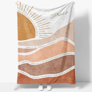 May include: A large, rectangular blanket with a warm color palette of browns, tans, and white. The design features a sun graphic and text that reads "Grace" and inspirational phrases. The blanket is made of soft material.