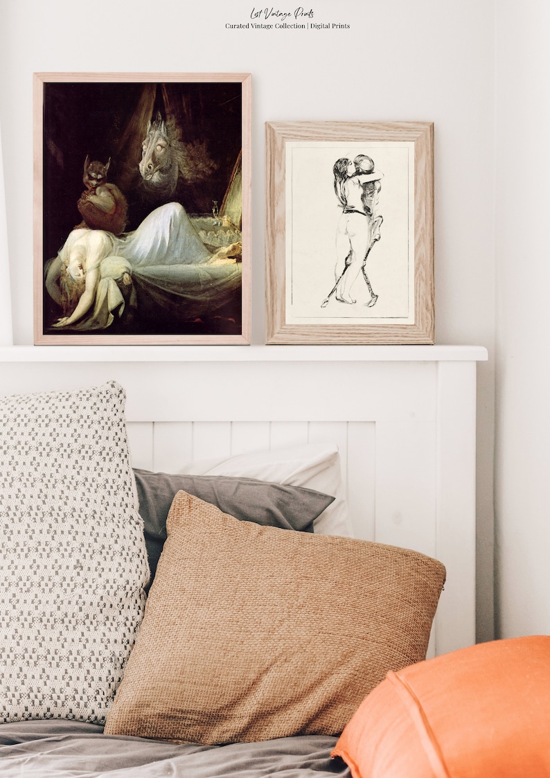 May include: Two framed art prints, one depicting a woman sleeping with a demon and a horse, the other depicting a couple embracing. The prints are hanging on a white wall above a bed with pillows.