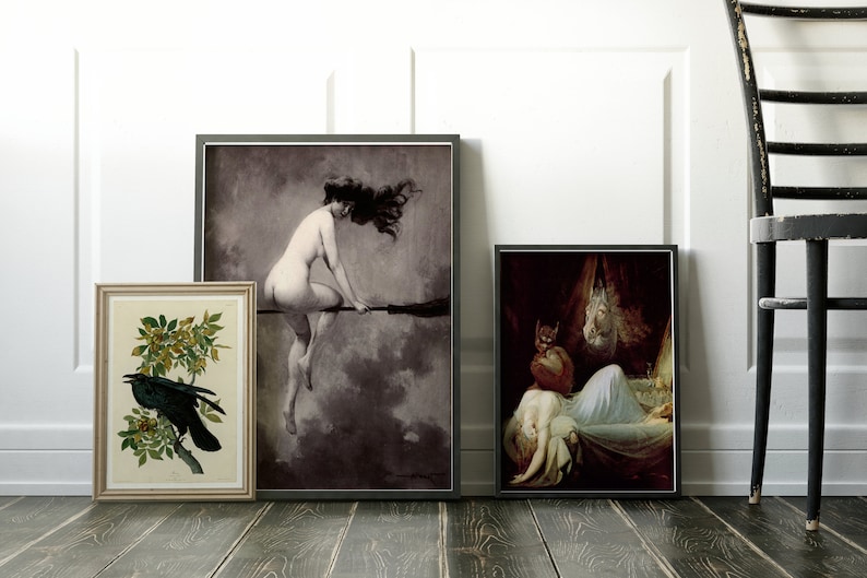 May include: Three framed art prints hanging on a white wall. The leftmost print features a black raven perched on a branch with yellow flowers. The center print shows a woman with long dark hair flying on a broomstick. The rightmost print depicts a woman lying in bed with a demon figure standing over her.