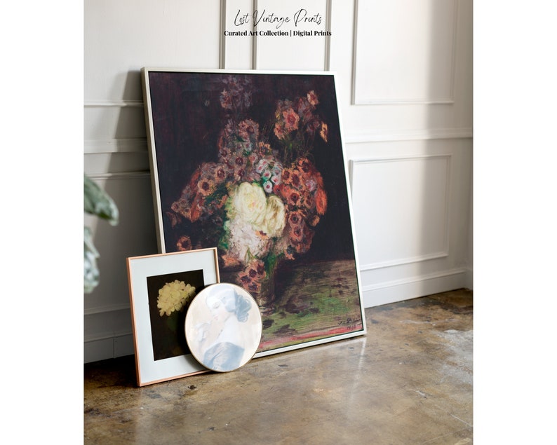 May include: A framed print of a still life painting featuring a bouquet of red, white, and pink flowers in a vase. The flowers are arranged in a vase on a dark green table. The painting is framed in a white frame.