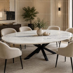 May include: An oval dining table with a white marble top featuring grey veining and a black metal cross-base, surrounded by six upholstered beige chairs with black legs. A ceramic vase with green foliage sits in the center of the table.