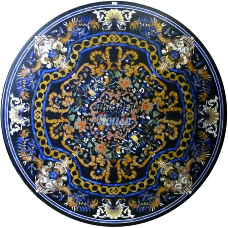May include: Round black marble table top with intricate floral and geometric patterns in shades of blue, gold, and white. The Art House is printed in the center.