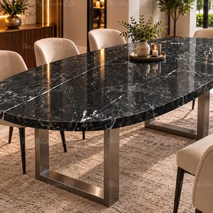 Puede incluir: Una mesa de comedor ovalada con una superficie de mármol negro pulido con vetas blancas, sostenida por dos patas de metal cepillado en forma de U. La mesa está rodeada por seis sillas tapizadas de color crema con patas de metal oscuro y bandeja.