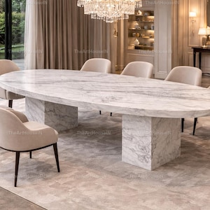 Op de afbeelding: Een ovale marmeren eettafel met een grijs en wit patroon, ondersteund door twee rechthoekige marmeren bases. De tafel is omringd door zes beige gestoffeerde stoelen met donkere houten poten. De kamer heeft een luxe, moderne uitstraling.