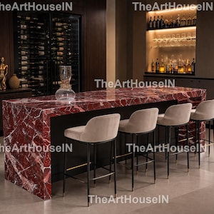 May include: A contemporary kitchen island featuring a red marble countertop and a black base. Four beige upholstered bar stools with black legs are in front. A wine rack and bar area are visible in the background.