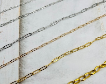 Könnte beinhalten: Fünf verschiedene Kettenarten in Silber und Gold. Die Ketten sind in Reihen auf einem weißen Hintergrund angeordnet. Die Ketten sind alle aus Metall und haben verschiedene Gliederformen und -größen.