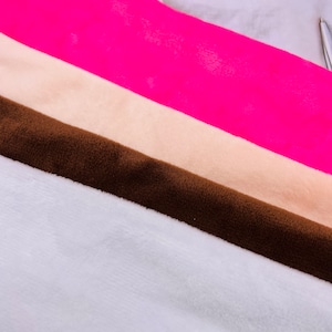 Könnte beinhalten: Vier Stoffmuster in verschiedenen Farben: Weiß, Braun, Beige und Pink. Die Muster sind diagonal angeordnet, wobei das weiße Muster unten und das pinke Muster oben liegt.