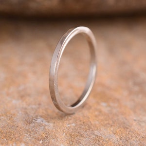 Puede incluir: Una sencilla alianza de plata con un borde ligeramente redondeado.