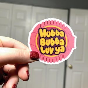 Może przedstawiać: Różowo-biała naklejka z tekstem "Hubba Bubba Luv ya" w żółtych i fioletowych literach.