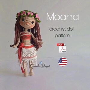 May include: Crochet doll pattern for a Moana doll. The doll is wearing a brown wig, a pink flower crown, a red and white top, and a white skirt with a red sash. The pattern is available as a PDF download. The image also includes the text "Moana crochet doll pattern" and a US flag.