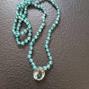 Necklace made of natural faceted blue apatite stones tied on a green silk thread, faceted aquamarine pendant.