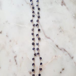May include: A delicate necklace with a gold chain and small, faceted amethyst beads. The necklace is approximately 18 inches long.