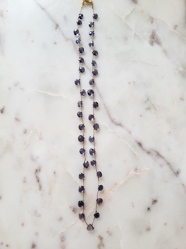 May include: A delicate necklace with a gold chain and small, faceted amethyst beads. The necklace is approximately 18 inches long.