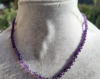 Necklace made of natural purple amethyst stones on green silk thread, faceted pear-shaped amethyst pendant.