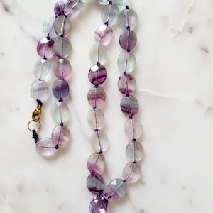 Necklace made of natural fluorite stones, with a faceted pear-shaped amethyst center stone. Purple necklace for women. Beads knotted on a thread.