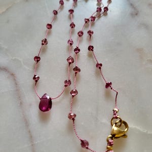 Halsband med naturlig rosa turmalinsten knutet på en silkestråd, hallonrosa granathänge. Delikat minimalistiskt halsband.