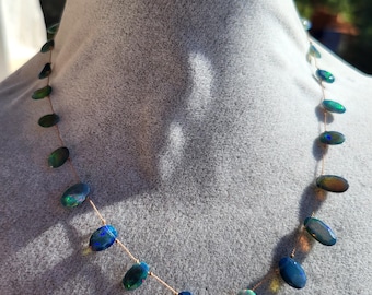 Collier de pierres naturelles d'opales noires fumées multiples reflets sur fil de soie forme ovale facettée. Collier minimaliste délicat.