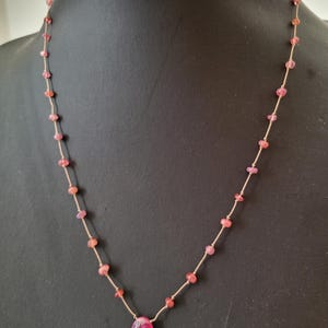 Halsketting van gladde, roze toermalijn natuurstenen, lange halsketting van stenen geknoopt op zijden draad, roze verhitte saffier hanger.