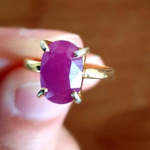 Peut inclure: Une bague en or avec une grande pierre précieuse violette de forme ovale et facetée.