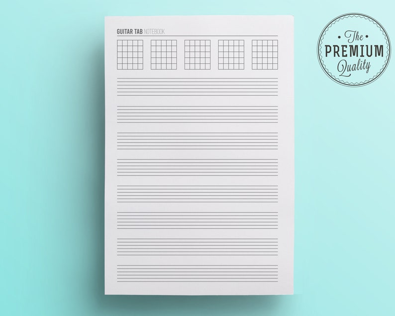 May include: A white Guitar Tab Notebook with a light blue background. The notebook features guitar tab diagrams at the top and horizontal lines for musical notation. The text "GUITAR TAB NOTEBOOK" is at the top, and a circular "The Premium Quality" seal is in the upper right corner.
