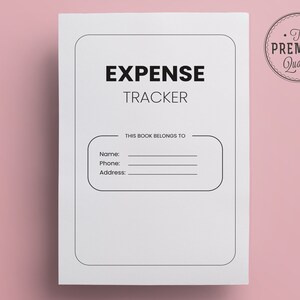 May include: A white expense tracker notebook with the words "EXPENSE TRACKER" in bold black letters. Below the title is a section to write the owner's name, phone, and address. A circular "The Premium Quality" seal is in the upper right corner.