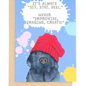 May include: Greeting card featuring a blue dog wearing a red beanie. The card has the text "IT'S ALWAYS 'SIT, STAY, HEEL.' NEVER 'IMPROVISE, IMAGINE, CREATE!'" on a light blue background with colorful paint splatters. The card is inside a brown envelope.