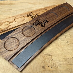 May include: A wooden serving tray with a black chalkboard insert. The tray has four cup holders and is engraved with the text "Dad's Bar".