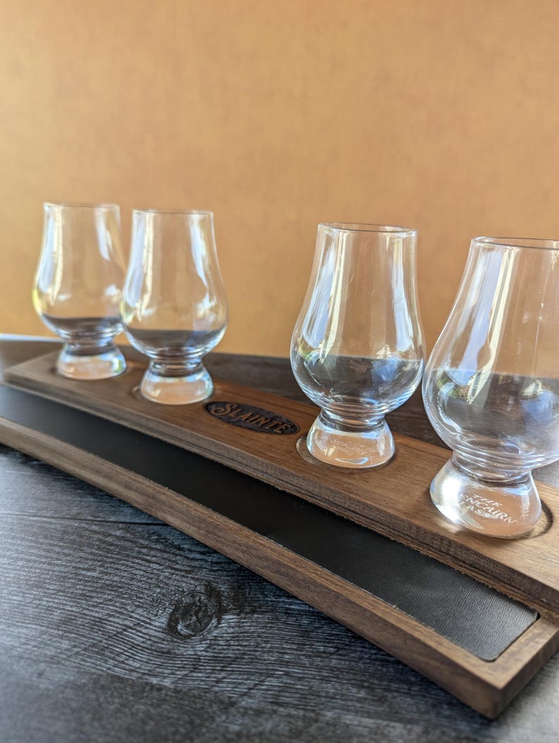 May include: A wooden tray with a black leather insert and four clear glass whiskey glasses. The tray is engraved with the word "Shauntee".