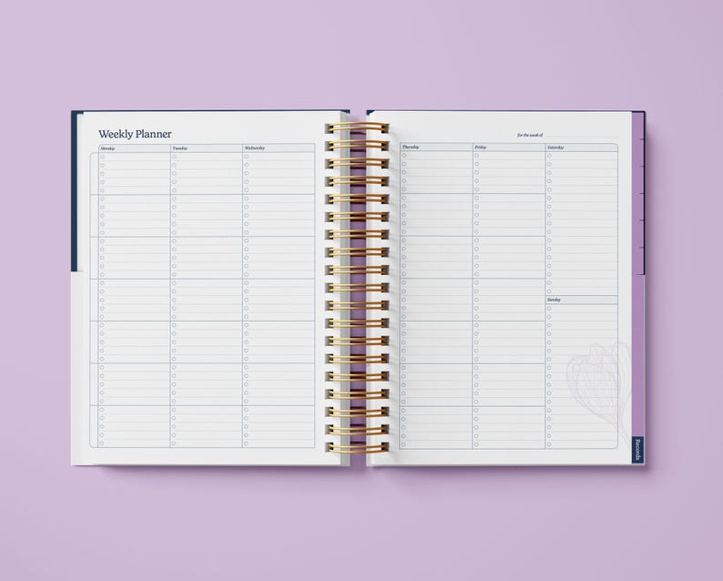 May include: An open weekly planner with a blue cover and gold spiral binding. The planner has a white interior with lined pages for daily scheduling.