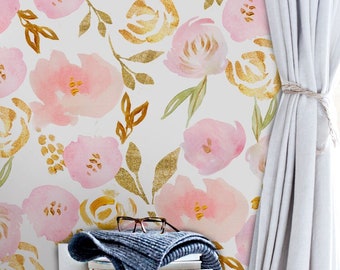 May include: Pink and gold floral wallpaper with a watercolor effect. The wallpaper features a repeating pattern of pink flowers with gold accents and green leaves. The wallpaper is shown in a room with a wooden dresser and a stack of books.