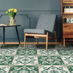 May include: A green and white patterned tile floor with a gray armchair, a black side table with a vase of yellow tulips, and a wooden bookcase in the background.