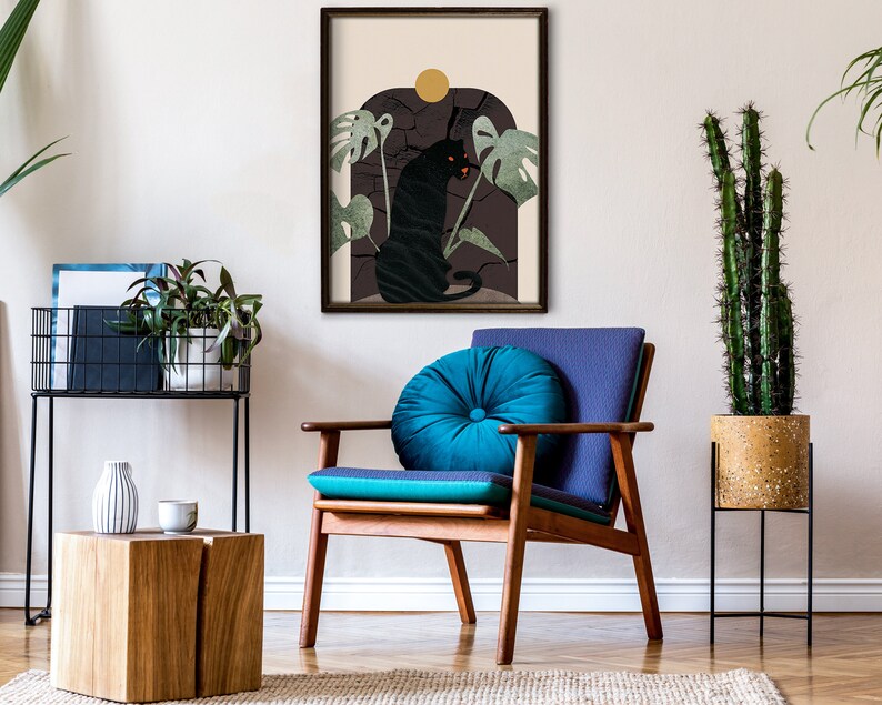 May include: A black panther illustration in a framed print with a dark green and brown background. The panther is sitting on a rock with a yellow sun behind it. The print is hanging on a white wall above a wooden chair with a blue cushion.