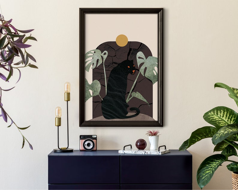 May include: A framed print with a black panther sitting in a jungle scene. The panther is surrounded by green leaves and a yellow sun. The background is a dark brown color.