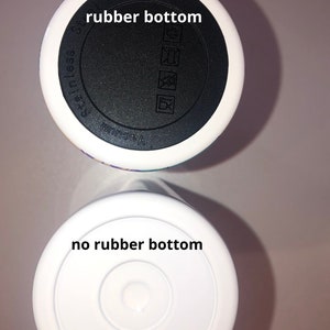 Puede incluir: Dos tazas de viaje blancas con fondos diferentes. La taza superior tiene un fondo de goma negro con las palabras "Vacuum" y "Stainless Steel" impresas en &eacute;l. La taza inferior tiene un fondo blanco sin goma.