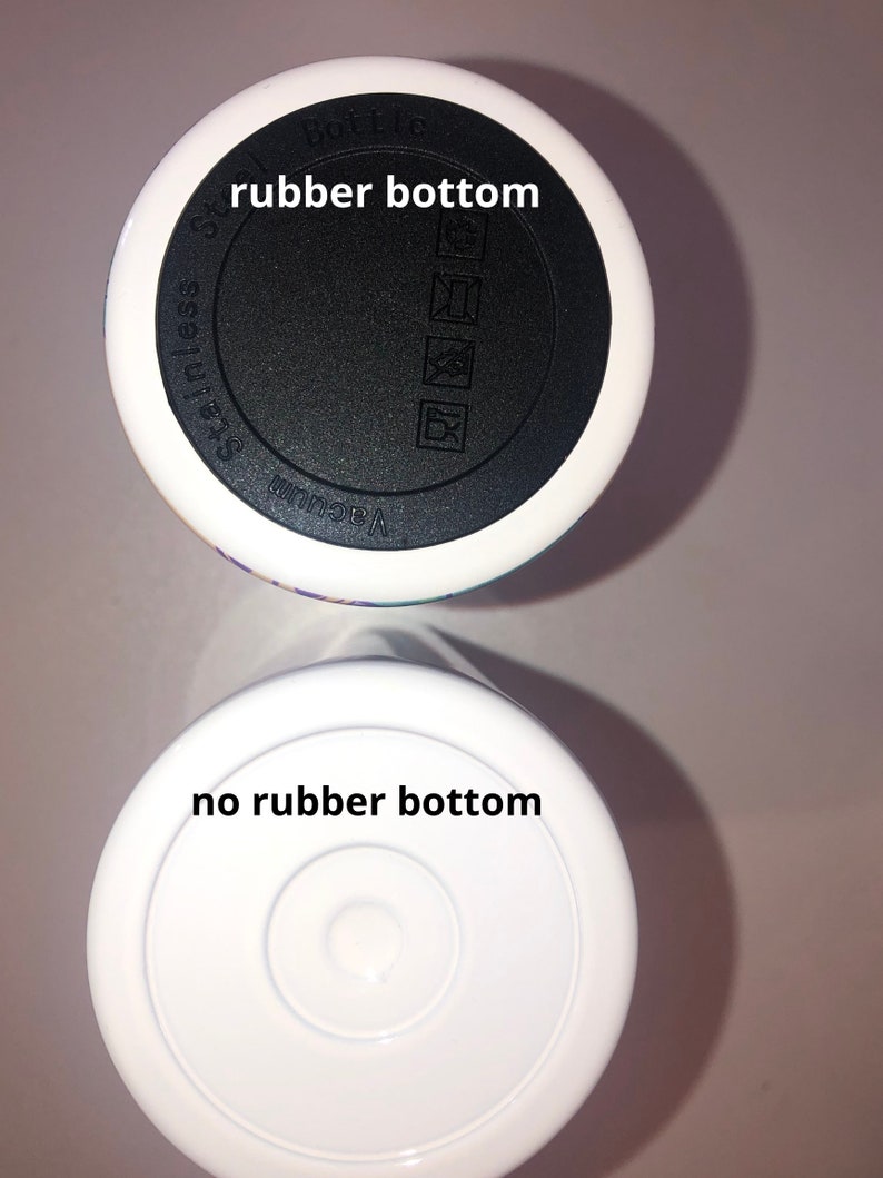 Puede incluir: Dos tazas de viaje blancas con fondos diferentes. La taza superior tiene un fondo de goma negro con las palabras "Vacuum" y "Stainless Steel" impresas en &eacute;l. La taza inferior tiene un fondo blanco sin goma.