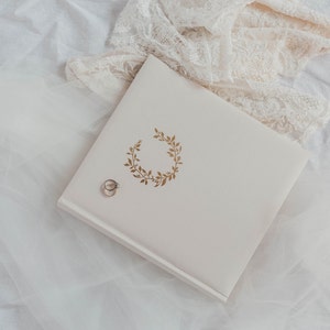 Oat and gold scrapbook photo album with wedding ring and wedding dress