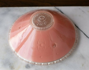 May include: A pink glass lampshade with a clear glass rim and a decorative etched design. The shade has a scalloped edge.
