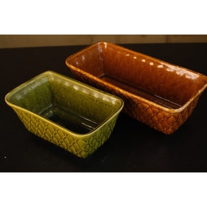 May include: Two ceramic loaf pans, one green and one brown, with a woven pattern. The pans are rectangular and have a glossy finish.