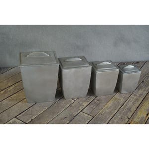 May include: A set of three ceramic mugs with a speckled, matte finish in cream, light grey, and dark grey. Each mug has a simple, minimalist design, suitable for coffee or tea.