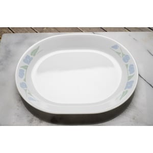 May include: White oval serving platter with a floral design. The platter has a light blue and green floral pattern around the rim. The serving dish is made of a durable material and is suitable for serving food.