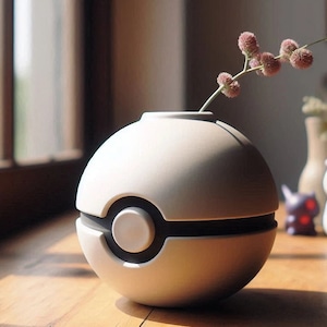 May include: A white ceramic vase shaped like a Pokeball with a sprig of pink flowers.