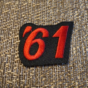 May include: Red embroidered patch with the number '61' on a black background.