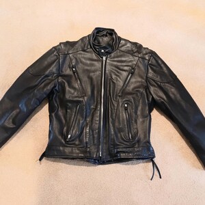 May include: A black leather motorcycle jacket with a zipper closure and multiple pockets.