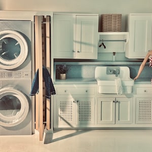 May include: A dollhouse laundry room with a white washer and dryer, a wooden drying rack, a white sink, and a doll wearing a red and white gingham dress.
