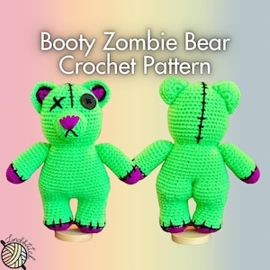 May include: Two green crocheted bear figures with black stitching and purple accents. One bear has an X for an eye and a button eye, the other has a stitched line for an eye. The bears are holding hands. The text "Booty Zombie Bear Crochet Pattern" is at the top.